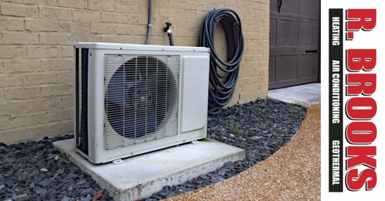 A heat pump next to a brick wall